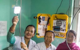 Nurses using a The Solar Suitcase developed by We Care Solar to electrify lighting.