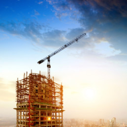 At dusk construction sites, large cranes and lifts.