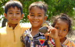 Children holding a Lucky Iron Fish stone.