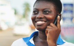 Woman using her mobile phone to buy affordable health insurance. MicroEnsure.