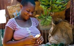 Kenyan woman using Totohealth tools via SMS for maternal and child health.