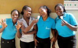 School girls smiling and holding up a hygienic pad by Ruby Cup.