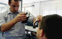 Doctor examining a patient with a mobile app for eye care diagnosis.