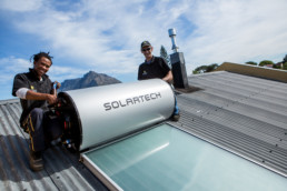 Men installing a Solartech a solar powered water heater.