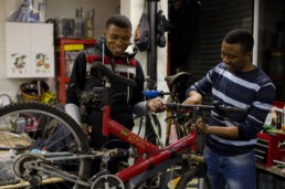 Men working on a bike in The Bike Project.