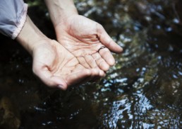 Woman collecting water with her hands. WaterStop