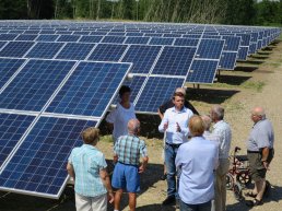 A group of people inspecting solar panels.