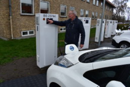 Man from Bornholm Municipality charging an electric vehicle. ACES.