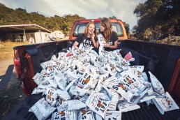 Advertisement for Chirps products. Two women on a bed truck with Chirps bags.