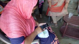 Woman using the Telenor app for birth registration.