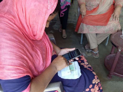 Woman using the Telenor app for birth registration.